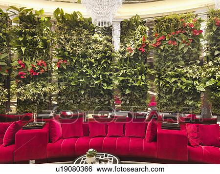 Walled red sofa with crystal chandelier and plants in restaurant View Large Photo Image Stock Photograph - Walled red sofa with crystal chandelier and plants in restaurant. Fotosearch