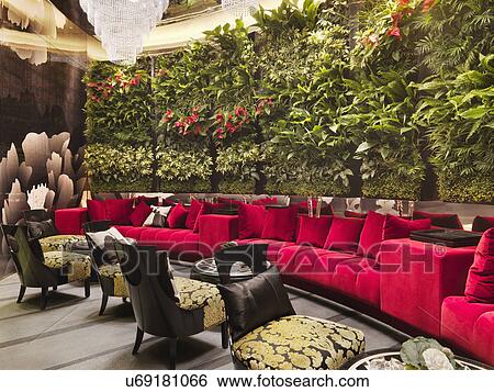 Walled red sofa with crystal chandelier and plants in restaurant View Large Photo Image Stock Photograph - Walled red sofa with crystal chandelier and plants in restaurant. Fotosearch