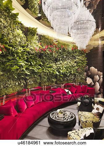 Walled red sofa with crystal chandeliers and plants in restaurant View Large Photo Image Stock Image - Walled red sofa with crystal chandeliers and plants in restaurant. Fotosearch