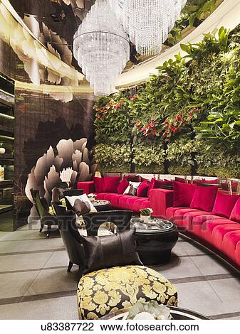 Walled red sofa with crystal chandeliers and plants in restaurant View Large Photo Image Stock Image - Walled red sofa with crystal chandeliers and plants in restaurant. Fotosearch
