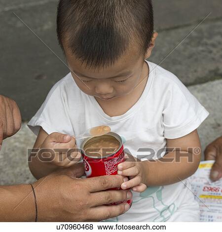 Stock Photo - Boy eating from a can at Forbidden City, Xicheng District, Beijing, China. Fotosearch