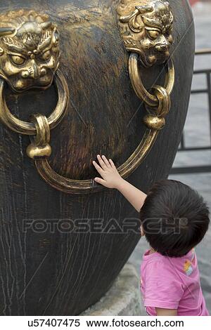 Stock Photography - Boy touching decorative urn at Forbidden City, Xicheng District, Beijing, China. Fotosearch