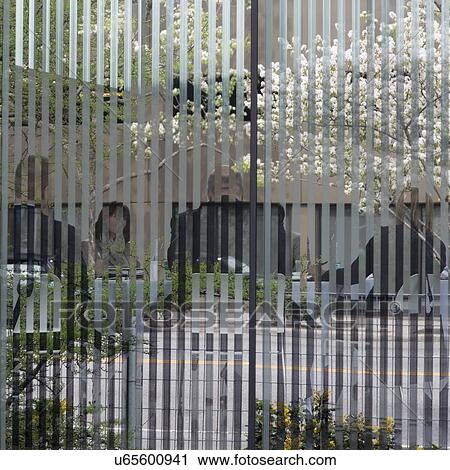 Stock Image - Business people having meeting in office viewed through window, Seattle, Washington State, USA. Fotosearch