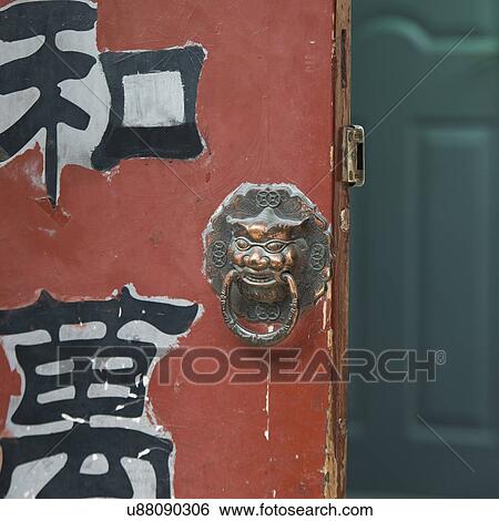 Stock Photograph - Close-up of a door with lion head, Hutong, Xicheng District, Beijing, China. Fotosearch