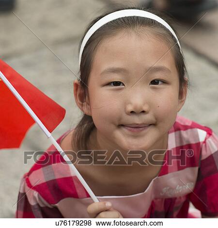 Stock Photo - Close-up of a girl holding Chinese flag at Forbidden City, Xicheng District, Beijing, China. Fotosearch