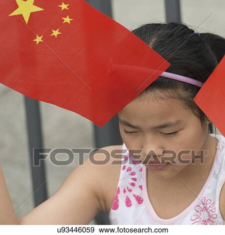 Stock Photo - Close-up of a girl holding Chinese flag at Forbidden City, Xicheng District, Beijing, China. Fotosearch