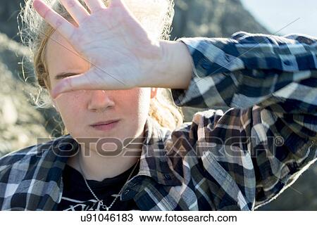 Stock Image - Girl covering face with hand, Long Point Hiking Trail, Crow Head, Twillingate, North Twillingate Island, Newfoundland And Labrador, Canada. Fotosearch
