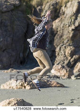 Stock Photo - Girl jumping on the beach, Twillingate, North Twillingate Island, Newfoundland And Labrador, Canada. Fotosearch