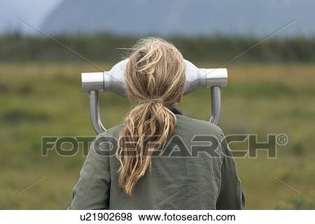 Stock Photo - Girl looking through a coin-operated binoculars, Western Brook Pond, Norris Point, Gros Morne National Park, Newfoundland And Labrador, Canada. Fotosearch