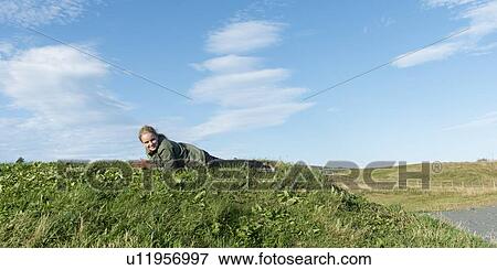 Girl lying on the grass, Witless Bay, Avalon Peninsula, Newfoundland And Labrador, Canada View Large Photo Image Stock Photo - Girl lying on the grass, Witless Bay, Avalon Peninsula, Newfoundland And Labrador, Canada. Fotosearch