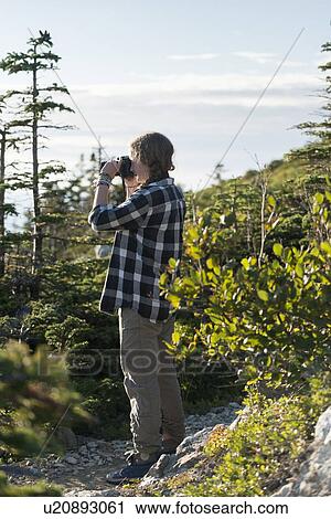 Stock Image - Girl taking pictures on Long Point Hiking Trail, Crow Head, North Twillingate Island, Newfoundland And Labrador, Canada. Fotosearch