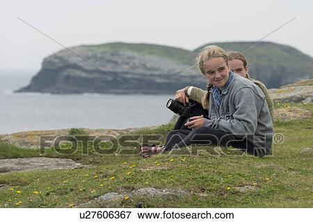 Stock Photo - Girls sitting at on the groumd, North Bird Island, Little Catalina, Bonavista Peninsula, Newfoundland And Labrador, Canada. Fotosearch