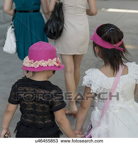 Stock Image - Girls walking on street, Dunhuang, Jiuquan, Gansu Province, China. Fotosearch