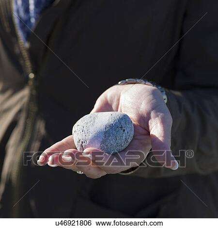 Stock Photograph - Hand holding a pebble, Twillingate, North Twillingate Island, Newfoundland And Labrador, Canada. Fotosearch