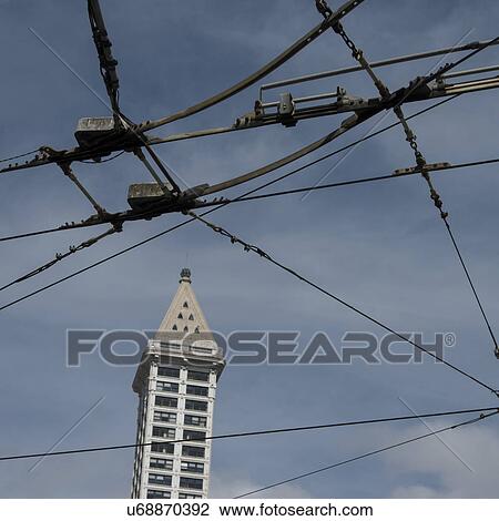 Stock Image - High-tension wires in front of a tower, Smith Tower, Pioneer Square, Seattle, Washington State, USA. Fotosearch