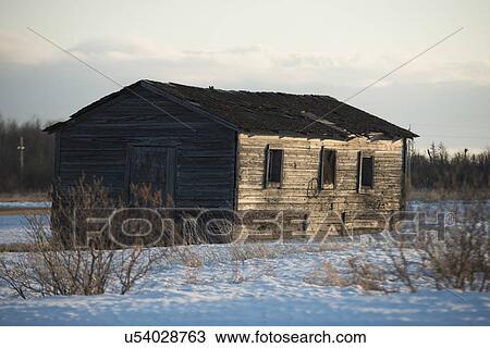 Stock Image - Log cabin in snow covered field at Hecla Grindstone Provincial Park, Manitoba, Canada. Fotosearch