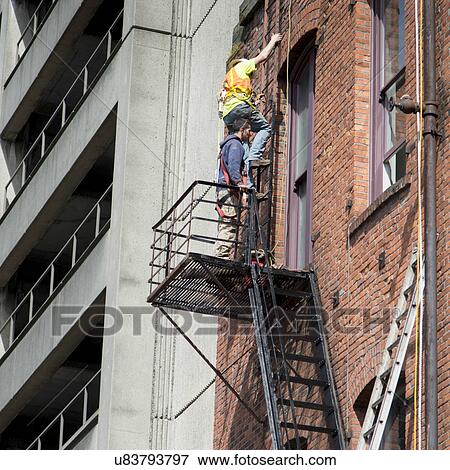 Stock Photo - Maintenance workers working at a building, Pioneer Square, Seattle, Washington State, USA. Fotosearch