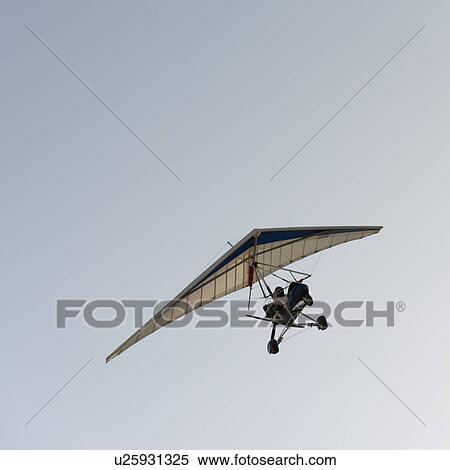 Stock Photography - Man gliding in the sky at Mingsha Shan, Dunhuang, Jiuquan, Gansu Province, China. Fotosearch