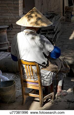 Man sitting on chair at Lei Yinsi Temple, Dunhuang, Jiuquan, Gansu Province, China View Large Photo Image Stock Photograph - Man sitting on chair at Lei Yinsi Temple, Dunhuang, Jiuquan, Gansu Province, China. Fotosearch