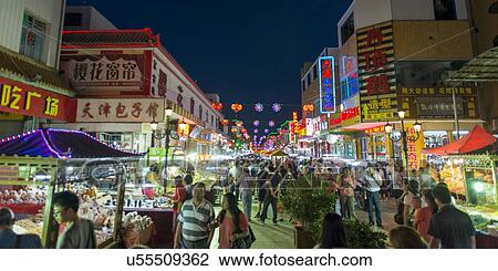Stock Image - People at Dunhuang Night Market, Dong Dajie, Dunhuang, Jiuquan, Gansu Province, China. Fotosearch