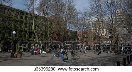 Stock Image - People at Occidental Park with buildings in the background, Pioneer Square, Seattle, Washington State, USA. Fotosearch