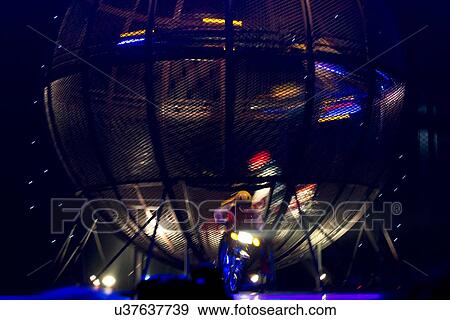 Stock Photo - Person performing stunt on a motorcycle at acrobatics show, Beijing, China. Fotosearch