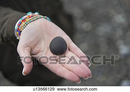 Stock Photo - Person showing stone on the palm, Deception Pass State Park, Oak Harbor, Washington State, USA. Fotosearch