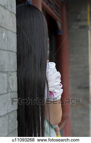 Stock Photo - Rear view of a woman leaning against wall, Suzhou Street, Summer Palace, Beijing, China. Fotosearch