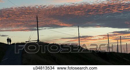 Picture - Silhouette of two people at sunset, Ferryland, Calvert, Avalon Peninsula, Newfoundland And Labrador, Canada. Fotosearch