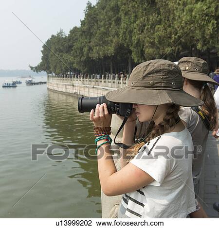Tourist taking picture of Kunming Lake with a digital camera, Summer Palace, Haidian District, Beijing, China View Large Photo Image Stock Image - Tourist taking picture of Kunming Lake with a digital camera, Summer Palace, Haidian District, Beijing, China. Fotosearch