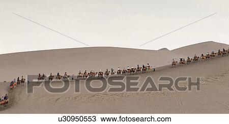 Tourists riding camels at Mingsha Shan, Dunhuang, Jiuquan, Gansu Province, China View Large Photo Image Stock Image - Tourists riding camels at Mingsha Shan, Dunhuang, Jiuquan, Gansu Province, China. Fotosearch