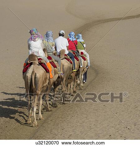 Tourists riding camels at Mingsha Shan, Dunhuang, Jiuquan, Gansu Province, China View Large Photo Image Stock Image - Tourists riding camels at Mingsha Shan, Dunhuang, Jiuquan, Gansu Province, China. Fotosearch