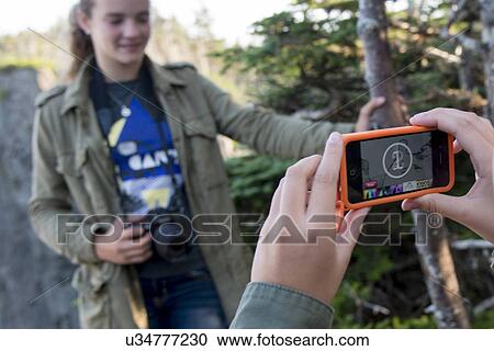 Stock Image - Tourists taking pictures with Smartphone on Skerwink Trail, Port Rexton, Bonavista Peninsula, Newfoundland And Labrador, Canada. Fotosearch