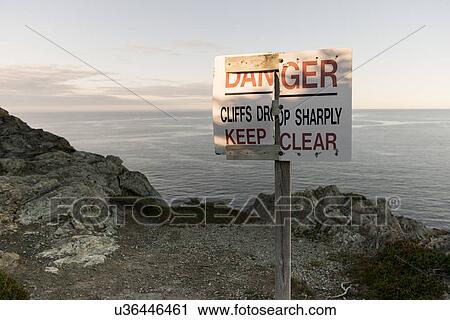 Stock Image - Warning signboard at coast, Long Point Hiking Trail, Crow Head, Twillingate, North Twillingate Island, Newfoundland And Labrador, Canada. Fotosearch