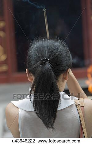 Woman praying with incense at Lama Temple, Dongcheng District, Beijing, China View Large Photo Image Stock Image - Woman praying with incense at Lama Temple, Dongcheng District, Beijing, China. Fotosearch