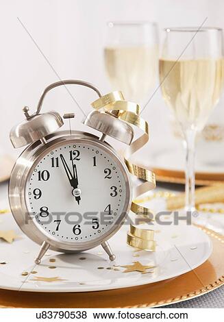 Stock Photo - Alarm clock with ribbons on plate. Fotosearch