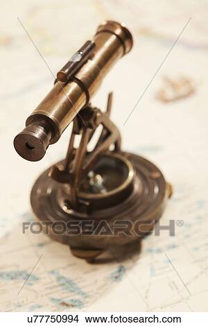 Picture - Antique telescope on map. Fotosearch