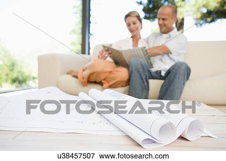 Blueprints on table, couple in background View Large Photo Image Stock Photo - Blueprints on table, couple in background. Fotosearch
