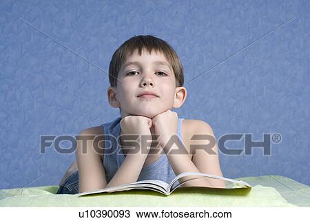 Boy (12-13) lying on bed, portrait View Large Photo Image Stock Image - Boy (12-13) lying on bed, portrait. Fotosearch