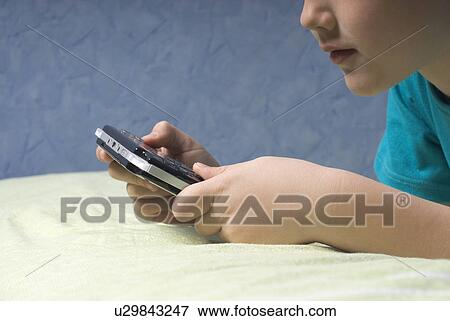Boy (12-13) playing video game, close-up View Large Photo Image Stock Photo - Boy (12-13) playing video game, close-up. Fotosearch