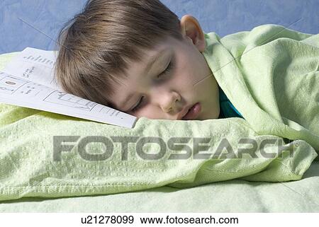 Stock Photo - Boy (12-13) sleeping with head on book. Fotosearch