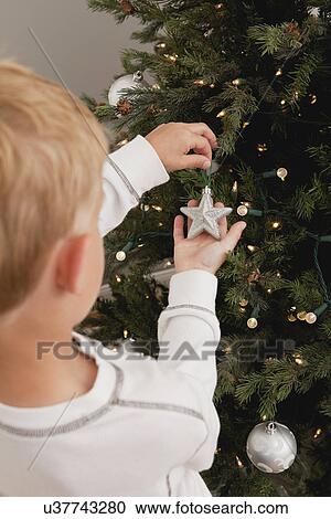 Boy (8-9) decorating christmas tree View Large Photo Image Stock Image - Boy (8-9) decorating christmas tree. Fotosearch