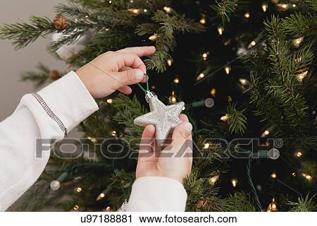 Boy (8-9)) decorating christmas tree View Large Photo Image Stock Image - Boy (8-9)) decorating christmas tree. Fotosearch