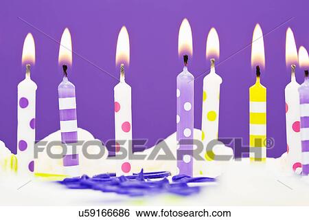 Stock Photograph - Burning candles on cake. Fotosearch