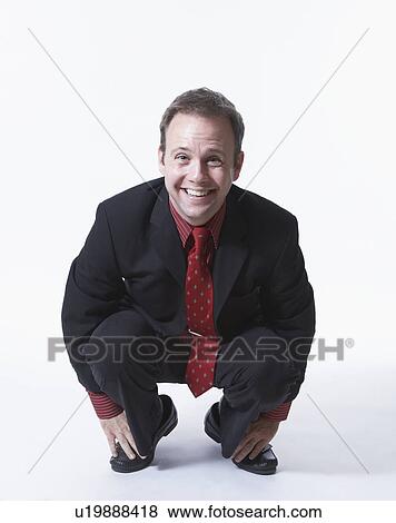 Stock Photo - Businessman crouching, portrait. Fotosearch