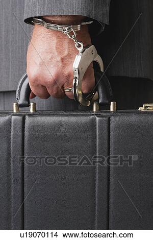 Picture - Businessman handcuffed to briefcase. Fotosearch
