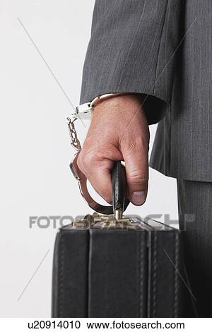 Businessman handcuffed to briefcase View Large Photo Image Stock Image - Businessman handcuffed to briefcase. Fotosearch