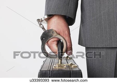 Businessman handcuffed to briefcase View Large Photo Image Stock Image - Businessman handcuffed to briefcase. Fotosearch