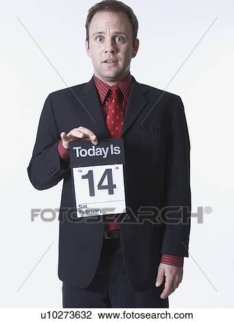 Stock Image - Businessman holding calendar, portrait. Fotosearch