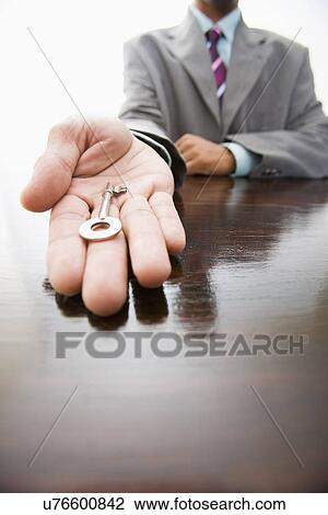 Businessman holding key, close-up View Large Photo Image Stock Image - Businessman holding key, close-up. Fotosearch